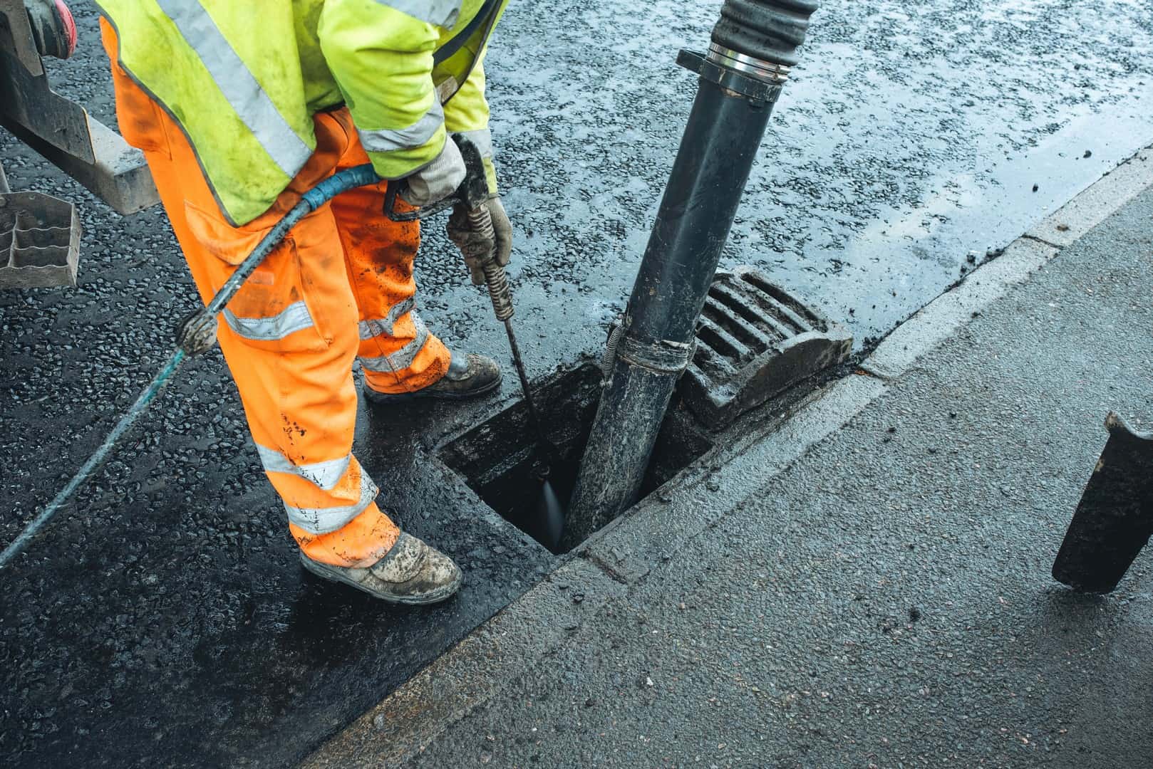 Drainage engineer clearing a roadside gully