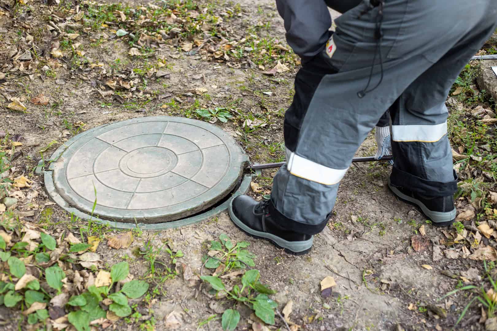 Drainage engineer inspecting a manhole cover