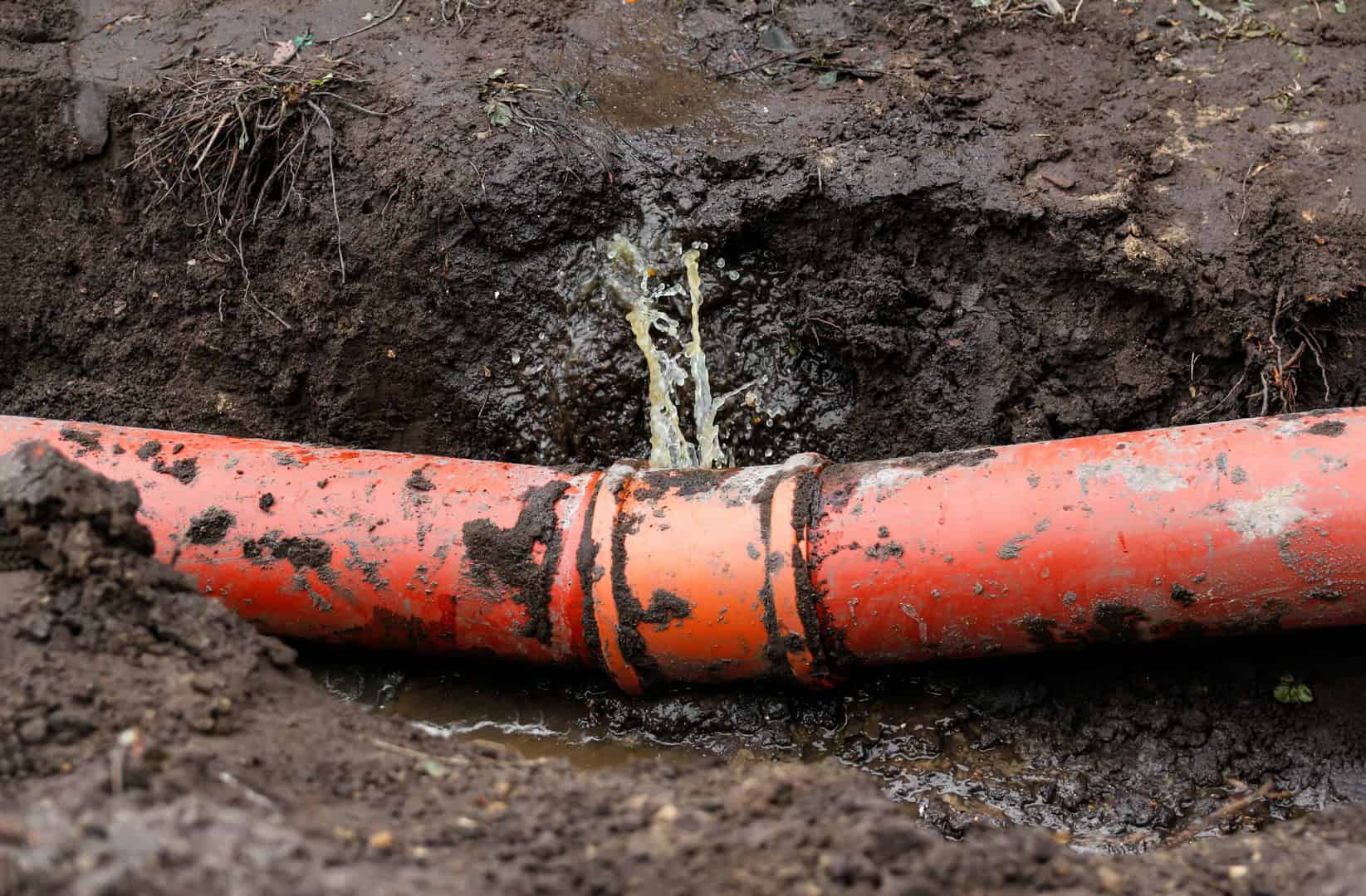 Damaged underground drainage pipe exposed for repair
